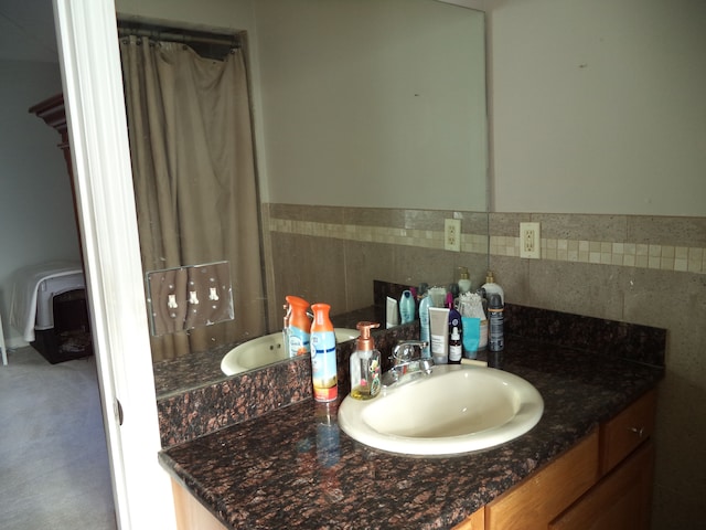 bathroom with tile walls, a shower with shower curtain, vanity, and wainscoting
