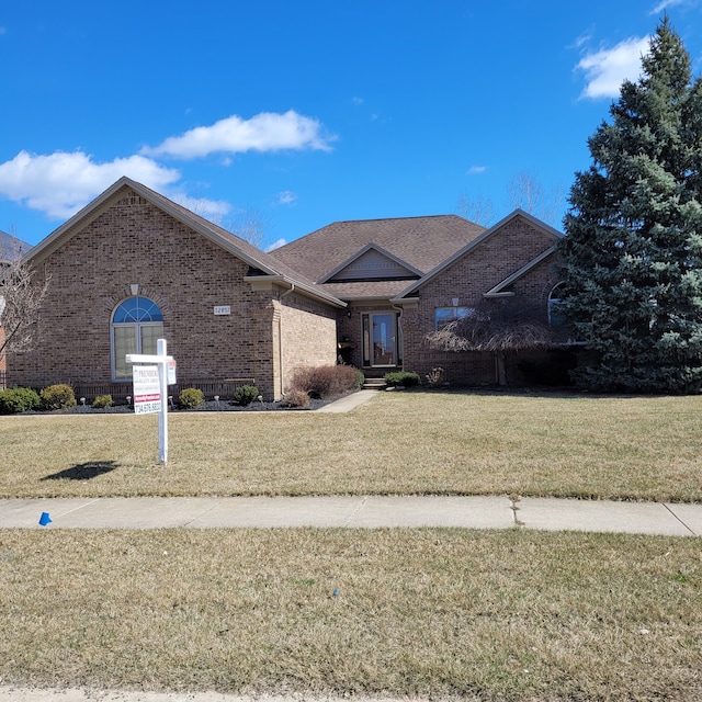 view of front of home with a front yard and brick siding
