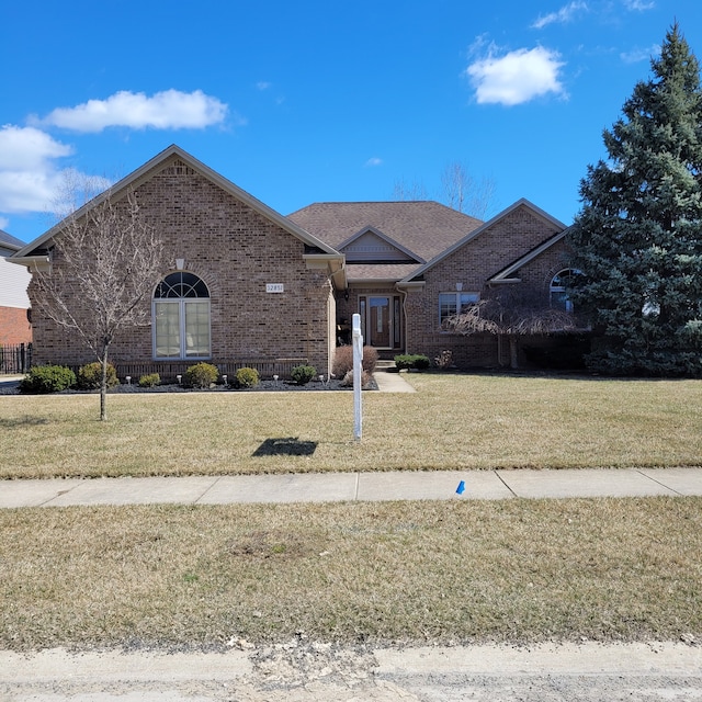 view of front of home with brick siding and a front yard