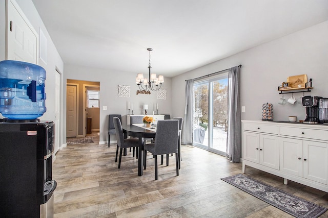 dining area featuring light hardwood / wood-style flooring and a notable chandelier