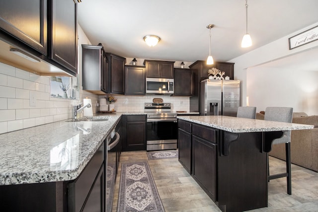 kitchen with pendant lighting, stainless steel appliances, a breakfast bar, and a kitchen island