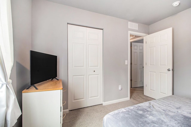 bedroom featuring light colored carpet and a closet