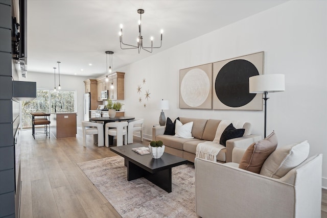 living room featuring light hardwood / wood-style floors, sink, and a chandelier