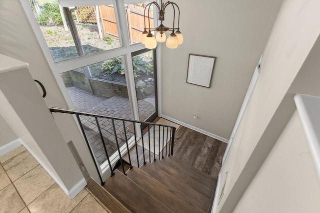 staircase featuring a chandelier and hardwood / wood-style flooring