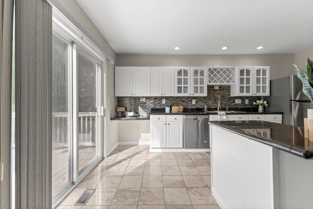 kitchen with stainless steel appliances, light tile patterned floors, white cabinets, and sink