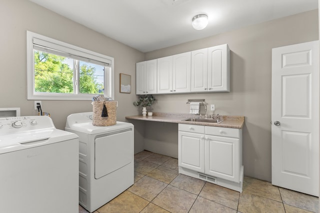 clothes washing area with sink, light tile patterned flooring, cabinets, and independent washer and dryer