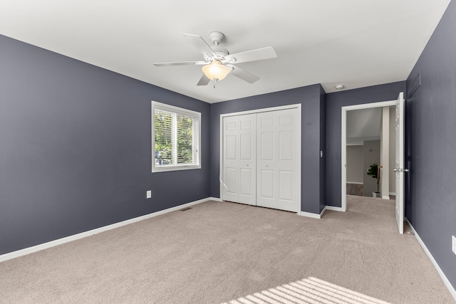 unfurnished bedroom with a closet, ceiling fan, and light colored carpet