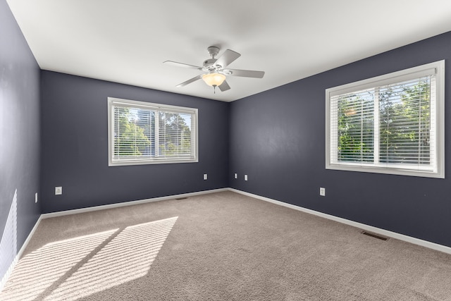 spare room with ceiling fan and light colored carpet