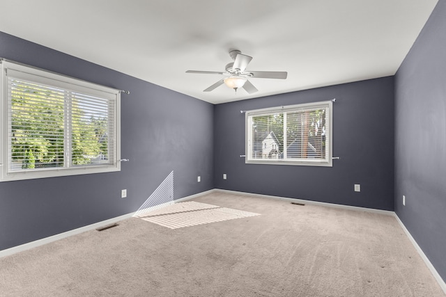 unfurnished room with ceiling fan and light carpet