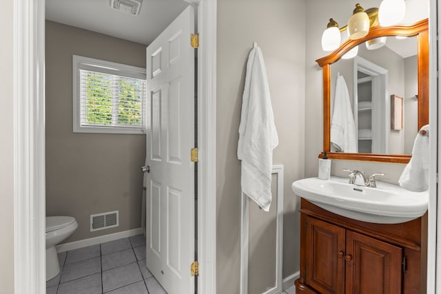 bathroom with toilet, tile patterned floors, and vanity