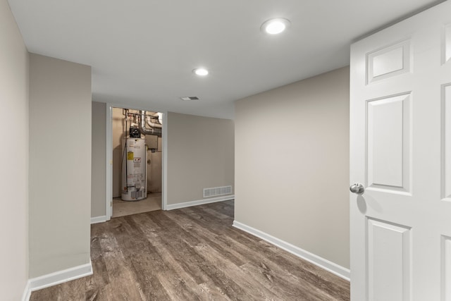 interior space with water heater and wood-type flooring