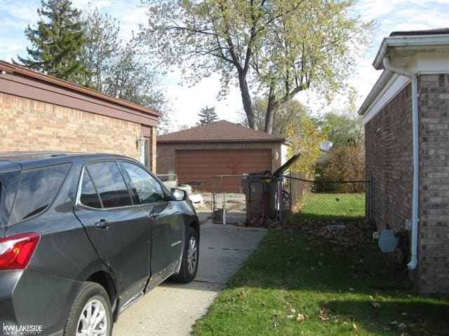 view of side of home featuring a lawn, an outbuilding, and a garage