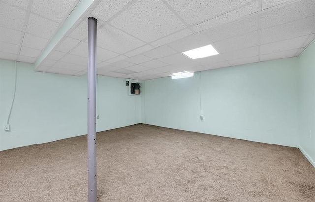 basement featuring a paneled ceiling and carpet