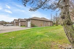 view of property exterior with a garage and a lawn