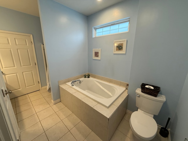 bathroom featuring a relaxing tiled tub, tile patterned floors, and toilet