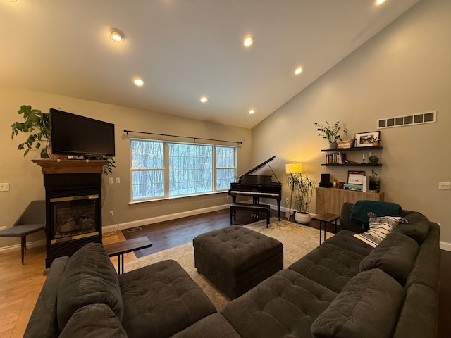 living room featuring hardwood / wood-style flooring and high vaulted ceiling