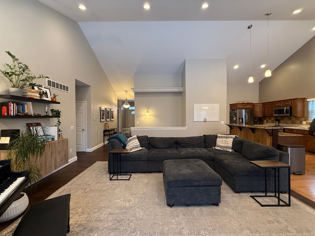 living room featuring high vaulted ceiling and light hardwood / wood-style floors