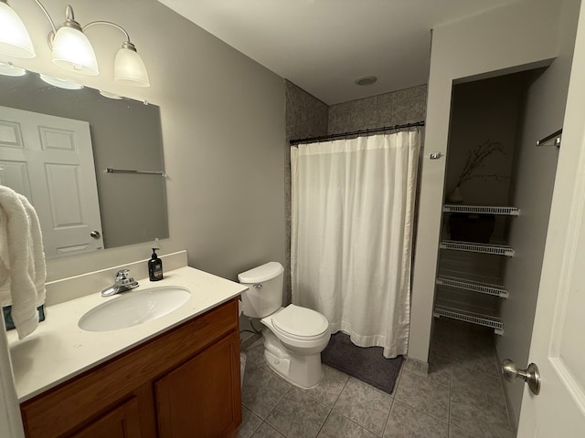 bathroom featuring toilet, vanity, a shower with curtain, and tile patterned floors