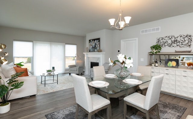 dining area with a premium fireplace, a chandelier, and dark hardwood / wood-style floors