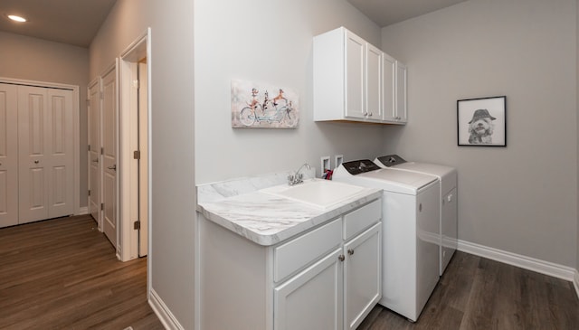 laundry area featuring sink, cabinets, washer and clothes dryer, and dark hardwood / wood-style floors