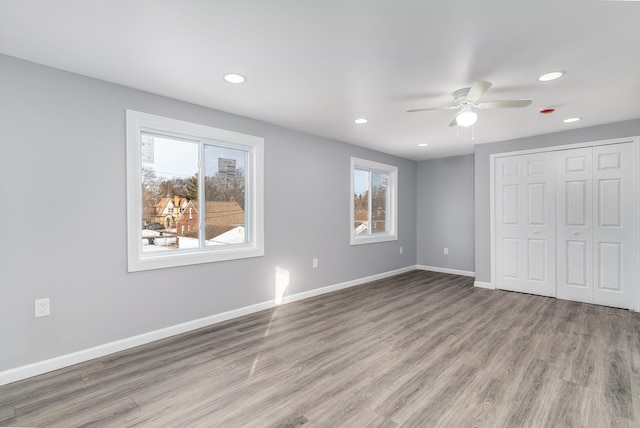 unfurnished bedroom with multiple windows, a closet, ceiling fan, and light hardwood / wood-style flooring