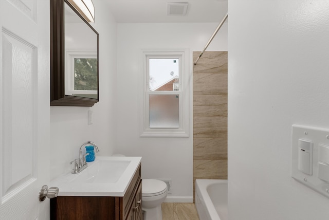 full bathroom featuring tiled shower / bath combo, vanity, and toilet