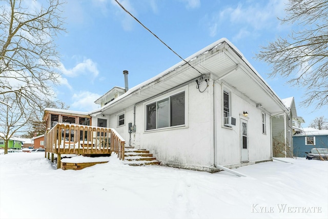 snow covered property with a wooden deck