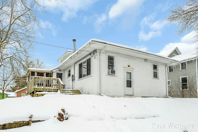 snow covered back of property with cooling unit