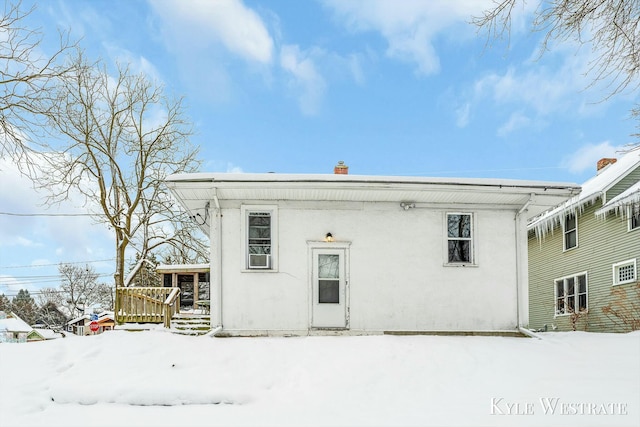 view of snow covered back of property