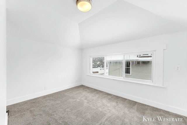 spare room featuring carpet floors and lofted ceiling