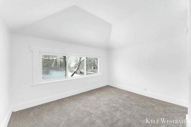 spare room with vaulted ceiling and carpet