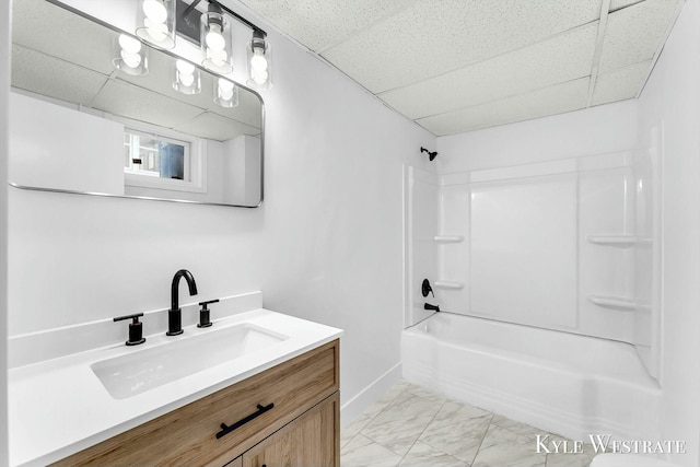 bathroom featuring a drop ceiling, shower / washtub combination, and vanity