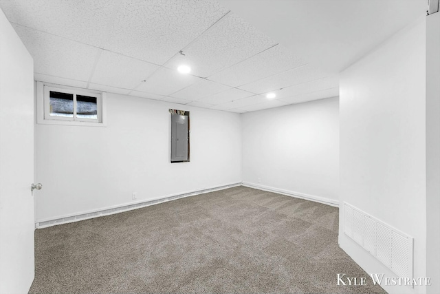 basement with electric panel, carpet floors, and a drop ceiling