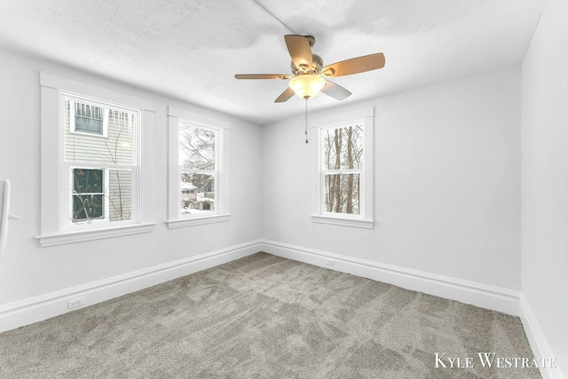 spare room featuring a textured ceiling, carpet floors, and ceiling fan