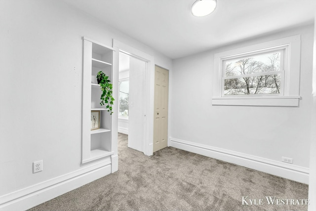 interior space with light colored carpet and built in shelves