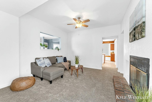 living room with a fireplace, ceiling fan, and carpet