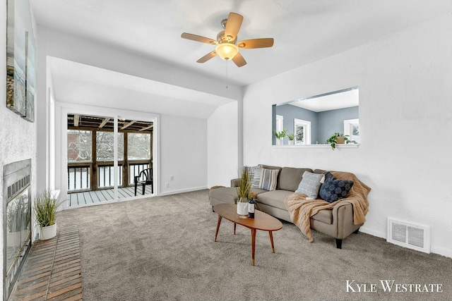 carpeted living room with ceiling fan and vaulted ceiling