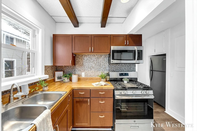 kitchen featuring sink, stainless steel appliances, dark hardwood / wood-style floors, and a drop ceiling