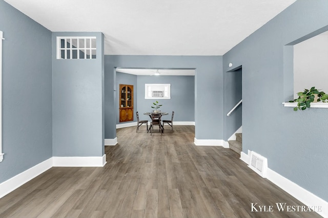 hallway featuring built in shelves and hardwood / wood-style flooring