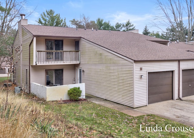 exterior space with a balcony, a garage, and central AC unit