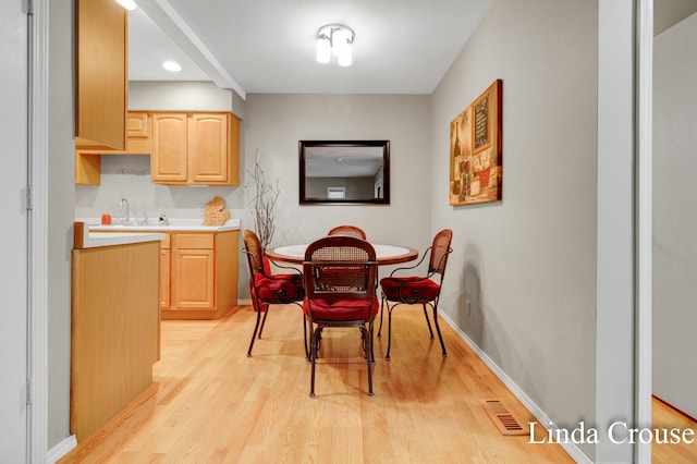 dining space with light hardwood / wood-style floors and sink