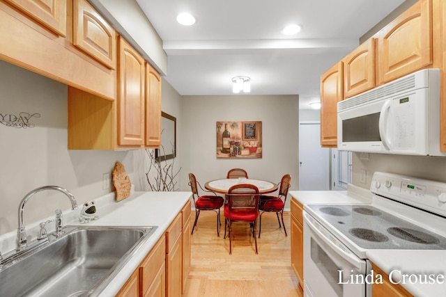 kitchen with sink, white appliances, light brown cabinetry, and light hardwood / wood-style flooring