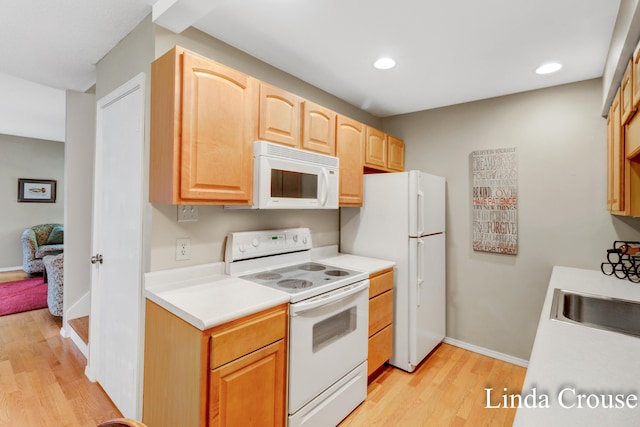 kitchen featuring white appliances, light hardwood / wood-style flooring, sink, and light brown cabinets