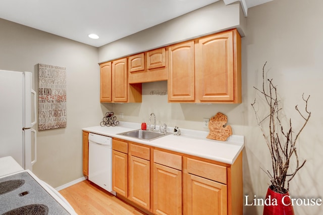 kitchen with white appliances, light hardwood / wood-style floors, and sink