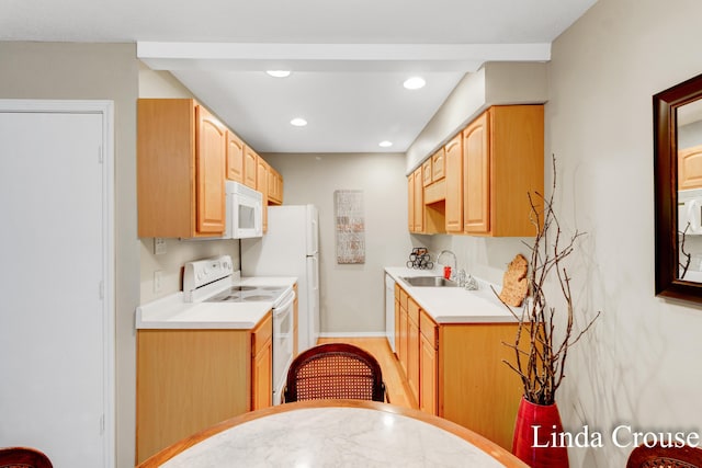 kitchen featuring white appliances, light brown cabinets, and sink