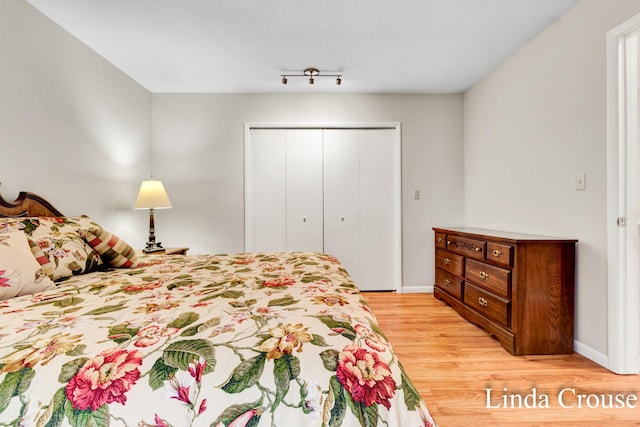 bedroom with light hardwood / wood-style floors and a closet