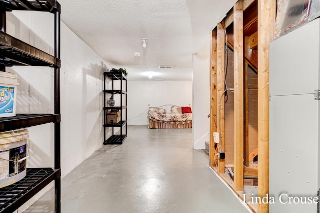 corridor with a textured ceiling and concrete floors