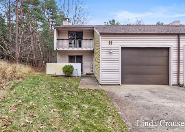 view of front of home with a garage, a balcony, and a front yard