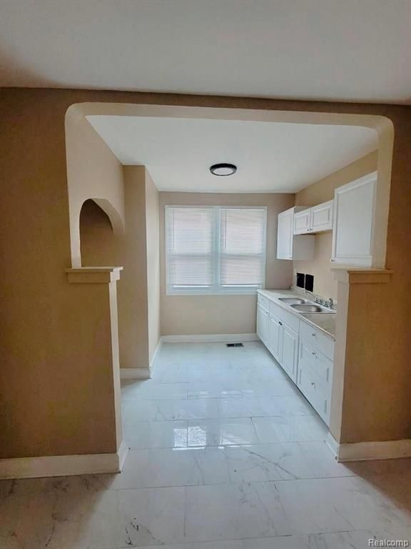 kitchen featuring white cabinets and sink