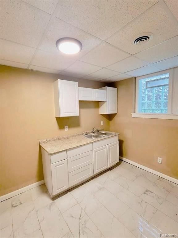 kitchen featuring sink, white cabinets, and a drop ceiling